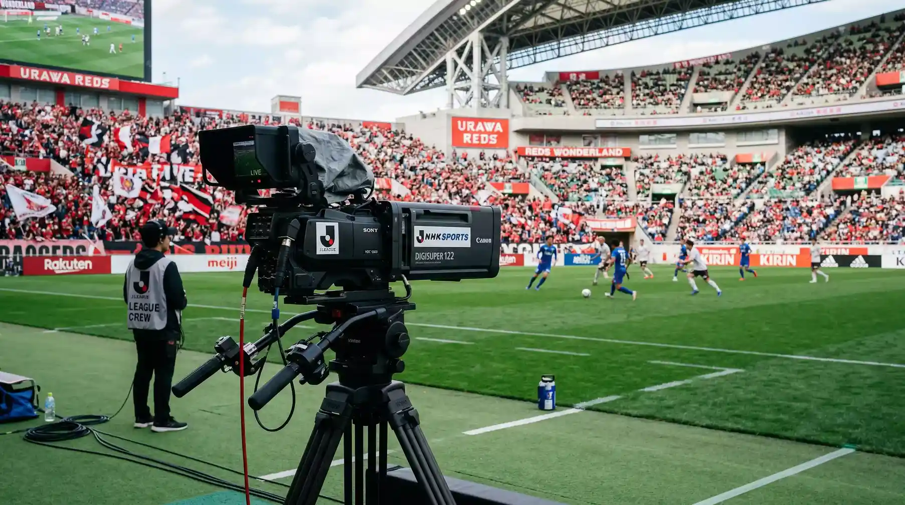 Cámara de televisión enfocando el campo de juego durante un partido de la J-League